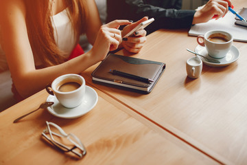 Pretty businesswomen working. Cute girls sitting at the caffee