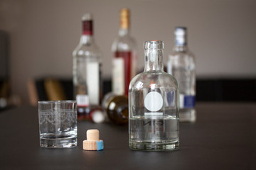 Several liquor bottles standing on a table and one bottle flipped on the table. Selective focus on one bottle. Selective focus