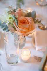 Vase of flowers on table with candle at wedding