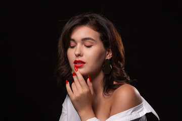 Beautiful woman with bright makeup posing isolated over black background.