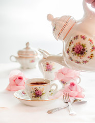 Tea time served with  fine china porcelain set with floral pattern. 