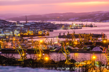 Fototapeta na wymiar Murmansk, Russia - January, 5, 2020: Non-freezing seaport in the city of Murmansk in winter. The picture was taken at 2 p.m. in natural light at the height of a polar night