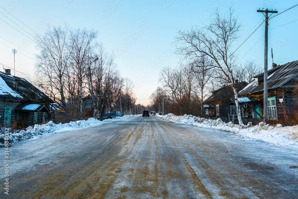 Canvas Prints Small wooden houses on a street of Rabocheostrovsky, Karelia, Russia, in winter at sunset.