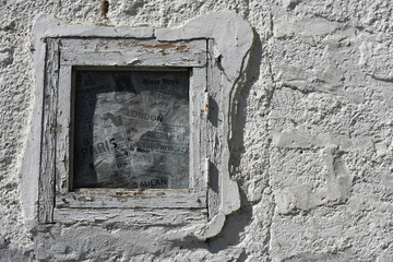 small window in a white textured old wall