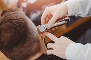 Hairdresser cuts hair men in barbershop. Barber doing correct beard trim electric shaver