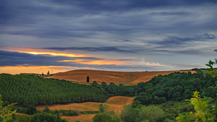 Fototapeta na wymiar Colorful dark sunset over the field. Travel destination Tuscany