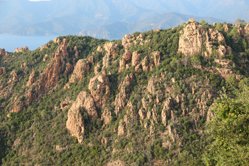 panorama of high clay-colored mountains surrounded by  green for