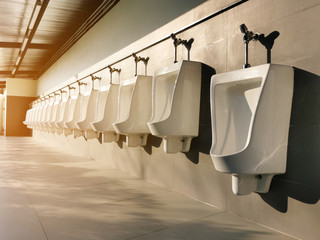 row of white urinals in public toilets, selective focus