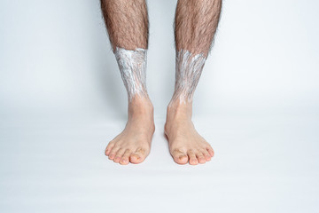 Legs hair removal for men. Apply hair removal cream to parts.