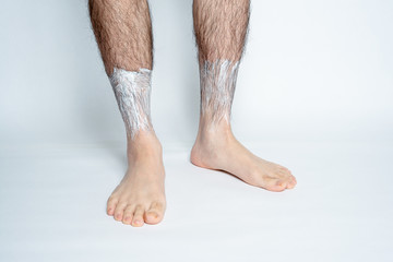 Legs hair removal for men. Apply hair removal cream to parts.