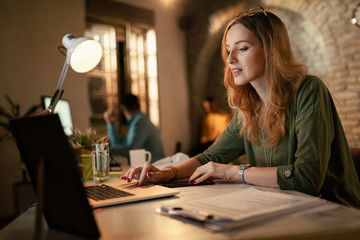 Young businesswoman working late on a computer in the office.