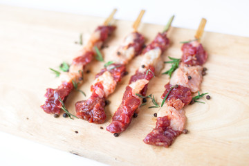 fresh raw beef meat with rosemary and pepper isolated on white