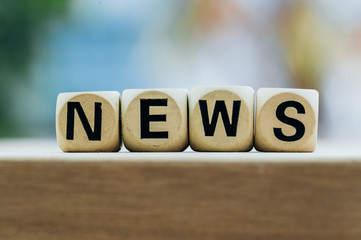 NEWS concept with wooden block on wooden table background.