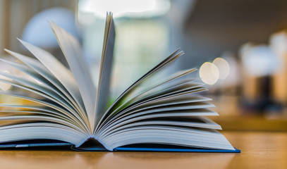 Open book lying on the table in the library