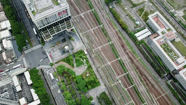 Top down shot, cars moving on the highway intersection, tall buildings and high speed railway in Kiaoshiung, Taiwan.