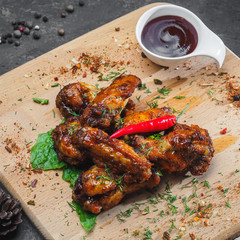 Fried chicken wings with pepper on wooden board
