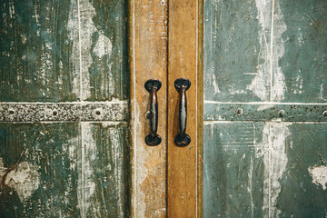Close up of vintage wooden locker or cabinet or other furniture with iron handles with closed doors