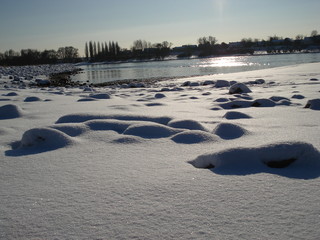 Schneebedecktes Flussufer als winterliches Idyll und Winterlandschaft lädt zum Winterspaziergang...