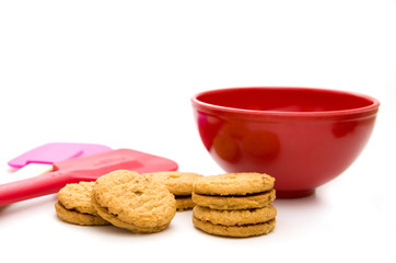 Cookies with Red Bowl and Red and Pink Spatula Isolated on White