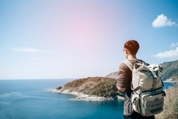 Fototapeta premium Man tourist with backpack on the mountain see the beautiful nature landscape of the sea