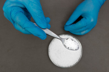 Plastic granules . Polypropylene, polyethylene pellets in hands with gloves. Quality control of plastic in the laboratory in production