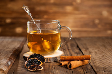  mug with tea on a wooden background with cinnamon, dry orange and star anise.