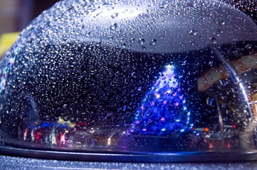 Christmas tree reflection in the cloche. Rain drops on meta. Wet cloche. 