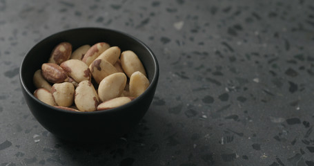 brazil nuts in black bowl on terrazzo countertop