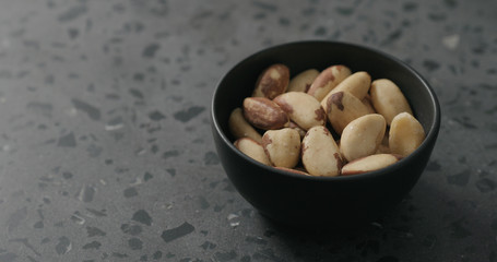 brazil nuts in black bowl on terrazzo countertop