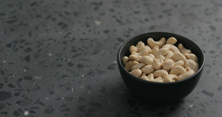 cashew nuts in black bowl on terrazzo countertop