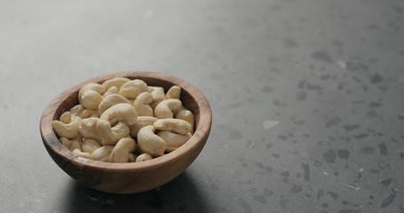 cashew nuts in olive bowl on terrazzo countertop
