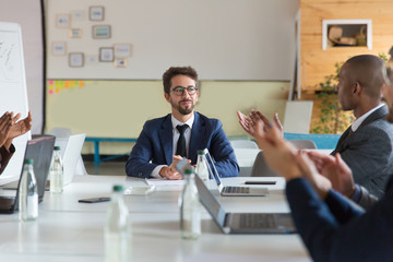Subordinates applauding project manager. Group of successful business people during morning briefing. Business meeting concept