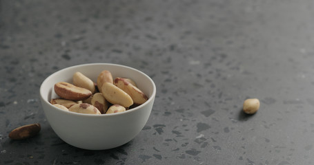 brazil nuts in white bowl on terrazzo countertop