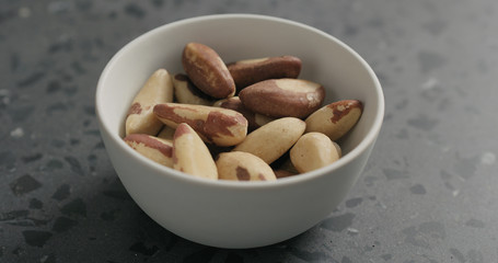 brazil nuts in white bowl on terrazzo countertop