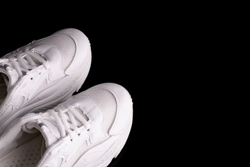 White running shoes. A pair of fashionable white sneakers on a black background.