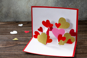 Valentine's Day greeting card or birthday present on wooden table. Children's art project crafts...