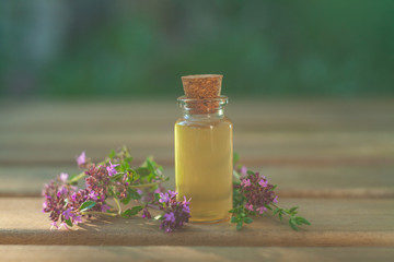 Obraz na płótnie Canvas thyme essential oil in beautiful bottle on table