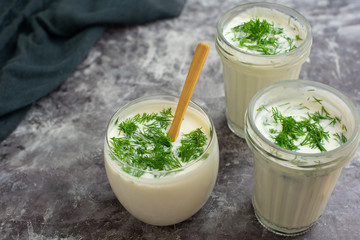 Kefir drink on gray background with dill