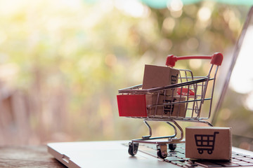 Shopping online concept - Parcel or Paper cartons with a shopping cart logo in a trolley on a...