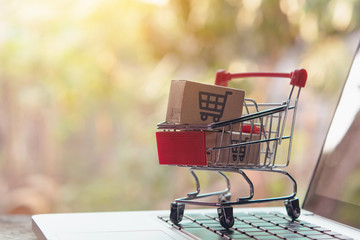 Shopping online concept - Parcel or Paper cartons with a shopping cart logo in a trolley on a...