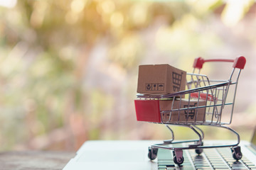 Shopping online concept - Parcel or Paper cartons with a shopping cart logo in a trolley on a...