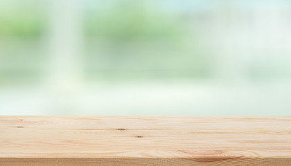 Empty wood table top on blur abstract green garden from window view