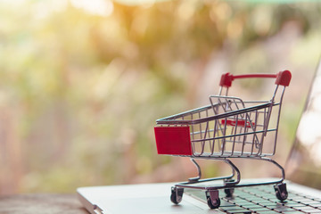 Shopping online concept - Empty shopping cart or trolley on a laptop keyboard. Shopping service on...