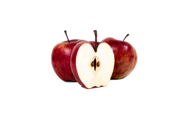 apple cut in half with seeds in the core and two apples in defocus on a white background.