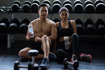 Fototapeta na wymiar couple break and drink water in gym