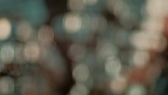 Abstract background. Warm glittery bokeh moving in horizontal direction.