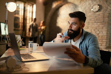 Young businessman working at night in the office.