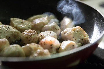 Diced chicken breast pan frying with black pepper and salt; healthy meal.