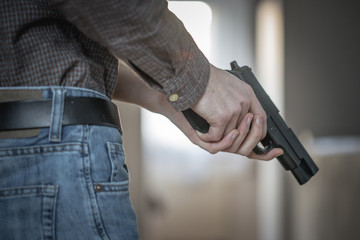 Police undercover weapon concept: Man is holding black weapon in his hand