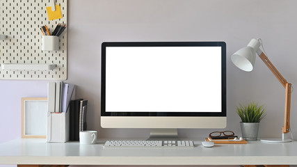 Creative Workspace. White blank screen computer on Office working desk. Equipment on table.
